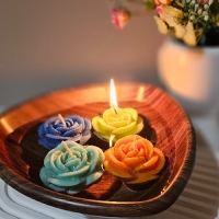 شمع گل رز شناور زیبایی روی آب در رنگ‌های جذاب